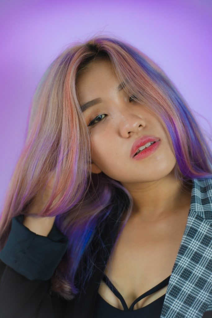 a woman with pink hair is posing for a picture