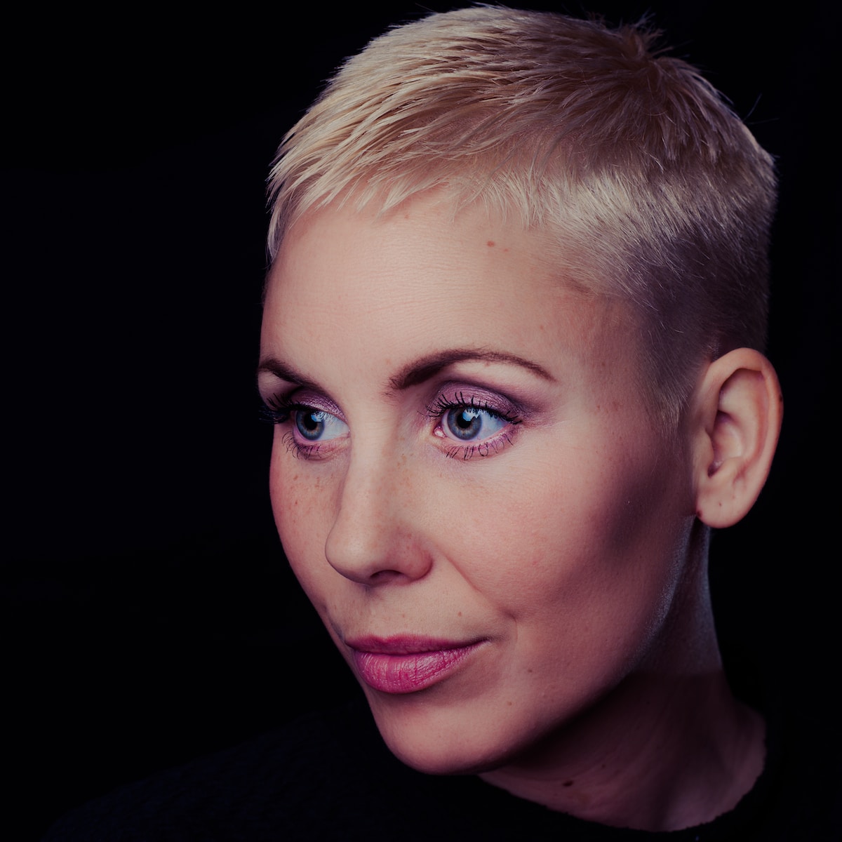 woman wearing crew-neck tee shirt with blonde short hair and pink lipstick